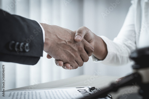 lawyer shake hands to congratulate the client because he was able to close the case successfully.