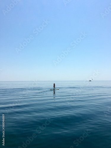 Sup board. water sport. a young man stands on a board in the sea