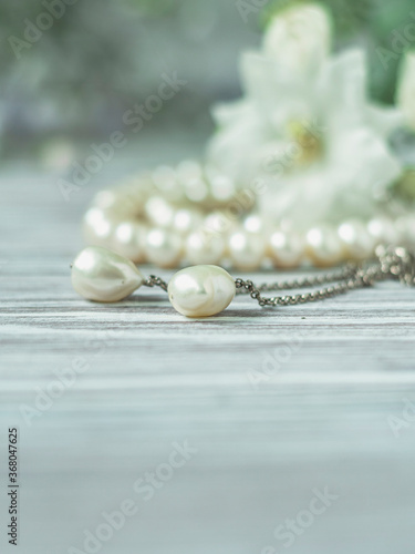 White pearl necklace with white flowers, macro.