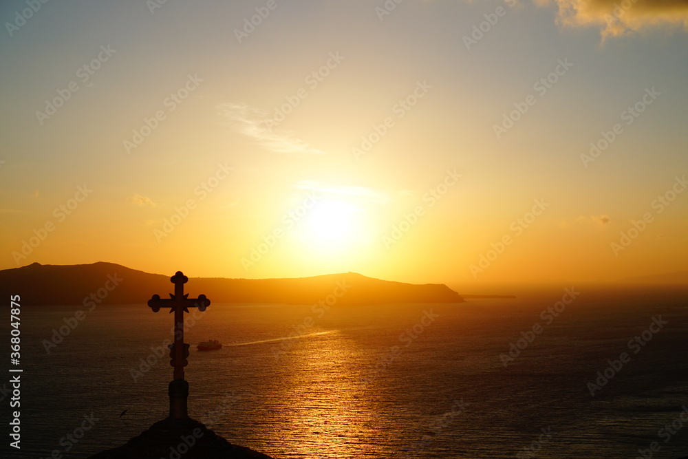 beautiful sunset with religious objects in santorini island, Oia, Greece, Europe