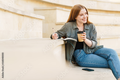 Attractive young girl writting in a notebook