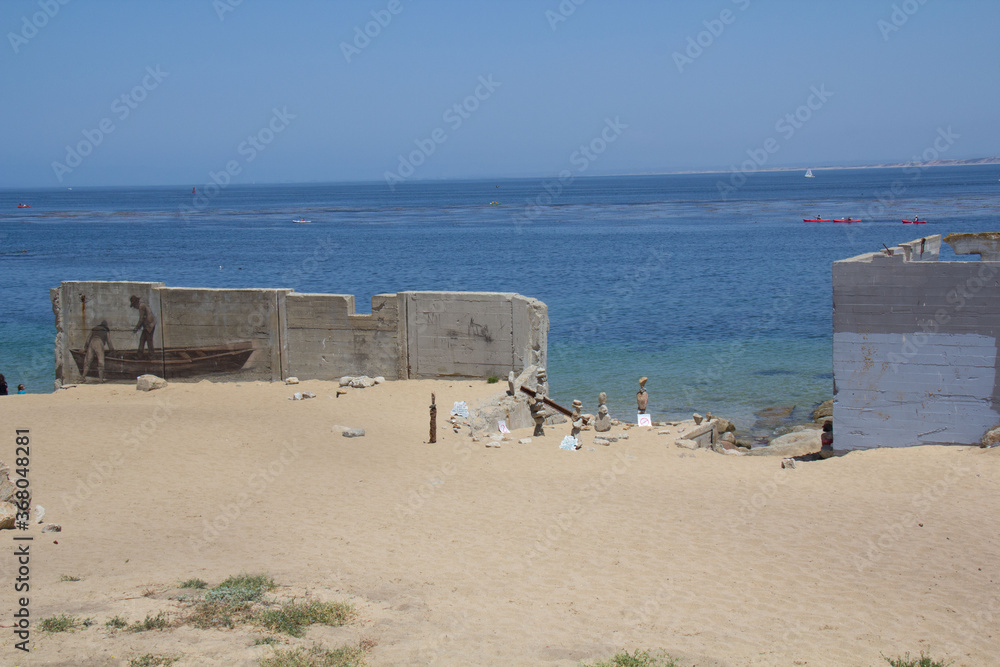 concrete wall on the beach with stacked rocks concrete wall on the beach with stacked rocks