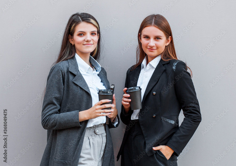 Two business women enjoying a cup of coffee and smiling Two business women enjoying a cup of coffee and smiling