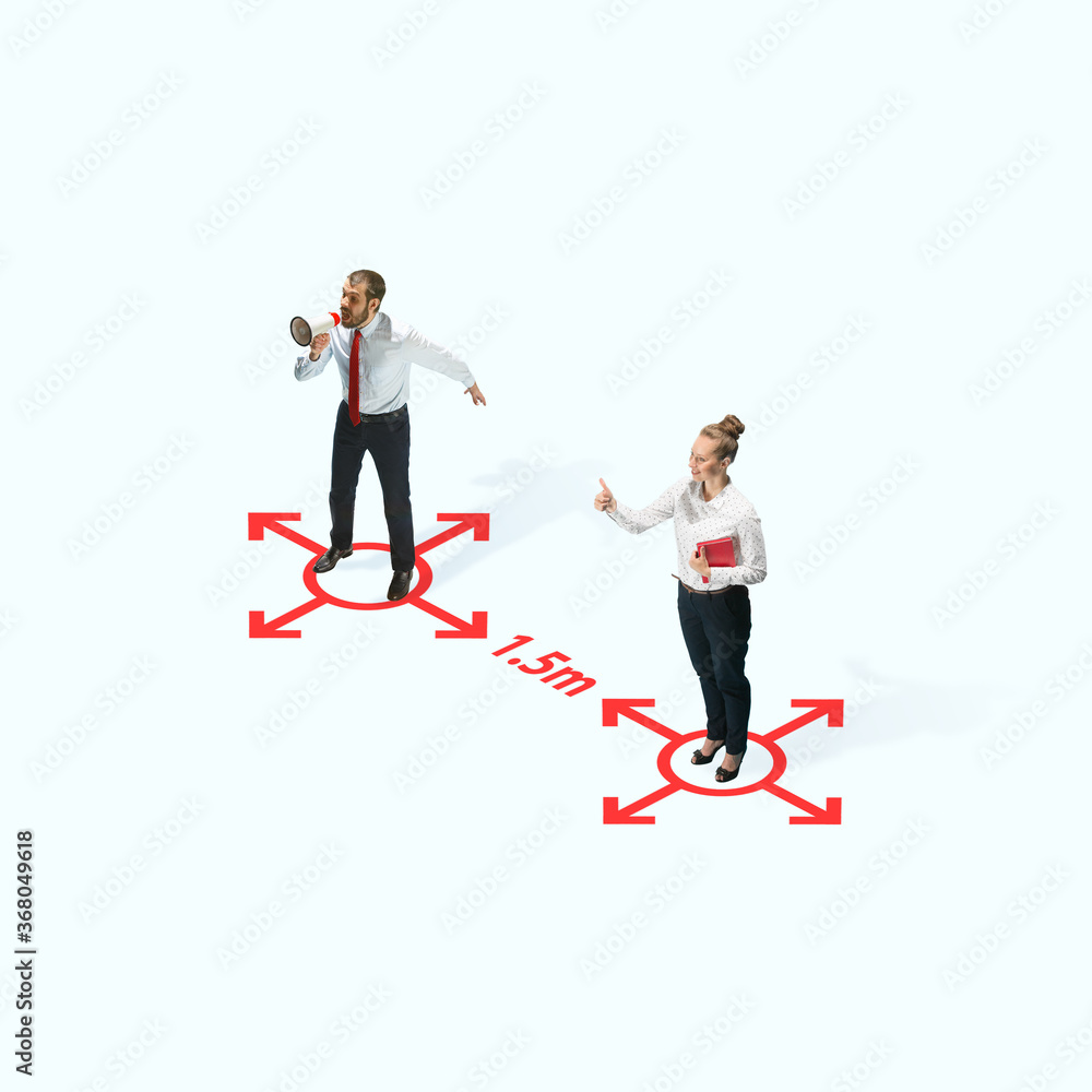 Studio shot of people demonstrating social distancing with arrows indicating the separation. Office workers during coronavirus outbreak with new rules for safety and healthcare. High angle view Studio shot of people demonstrating social distancing with arrows indicating the separation. Office workers during coronavirus outbreak with new rules for safety and healthcare. High angle view