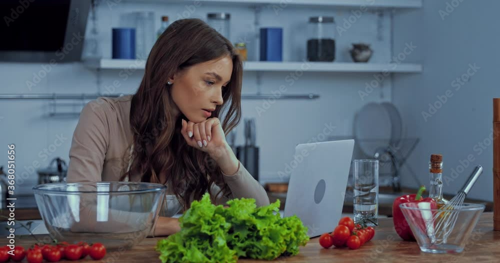 attractive woman using laptop near ingredients on table attractive woman using laptop near ingredients on table