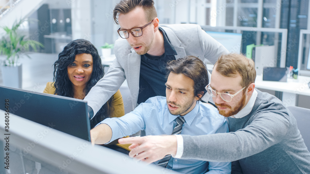 In Modern Office: Diverse Team of Businessmen and Businesswoman Work on Computer, Having Discussion, Trying to Find Problem Solution Collectively. Young Businesspeople Talk and Pointing on Screen