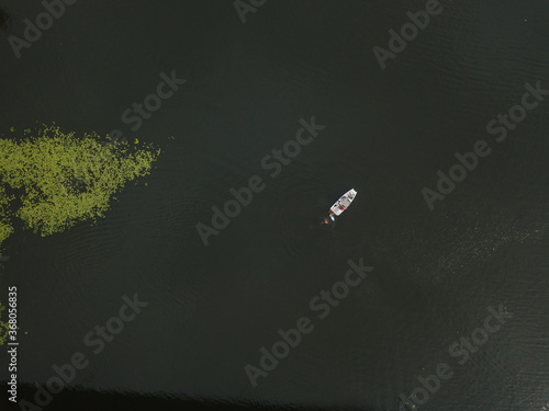 Aerial drone view. Motor boat on the water next to the lilies.