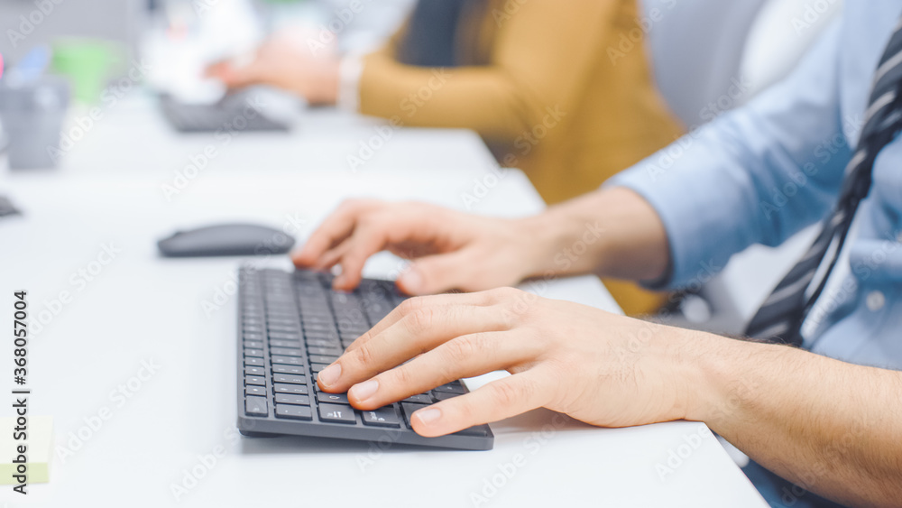 Close-up Shot of Man typing on a Keyboard, Using Mouse. Businessman / Office Clerk Working on Desktop Computer in Bright Office Close-up Shot of Man typing on a Keyboard, Using Mouse. Businessman / Office Clerk Working on Desktop Computer in Bright Office