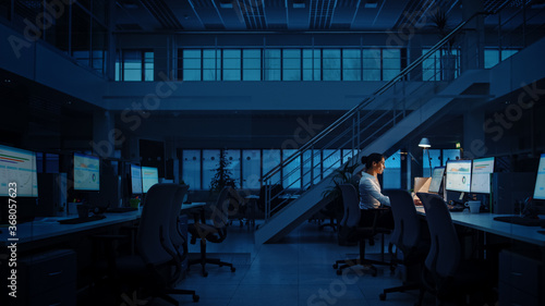 Alone Working Late at Night in the Office: Businesswoman Using Desktop Computer, Analyzing, Using Documents, Solving Problems, Finishing Project