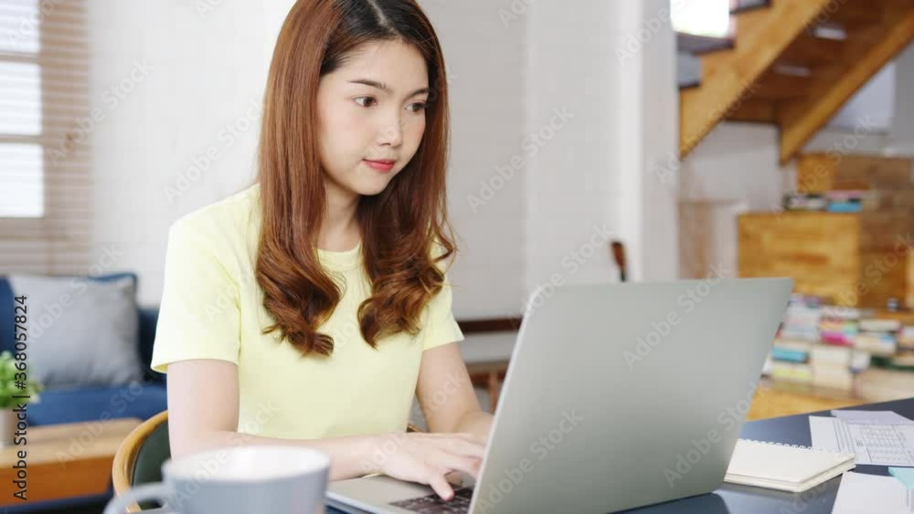 Portrait of freelance Asia women casual wear using laptop working in living room at home. Working from home, remotely work, self isolation, social distancing, quarantine for corona virus prevention. Portrait of freelance Asia women casual wear using laptop working in living room at home. Working from home, remotely work, self isolation, social distancing, quarantine for corona virus prevention.