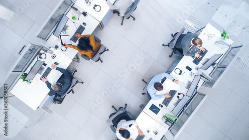 Top Down Shot of Big Busy Corporate Office with Tow Rows off Businessmen and Businesswomen Working on Desktop Computers. Bright Open Space Office with Businesspeople and Salespeople