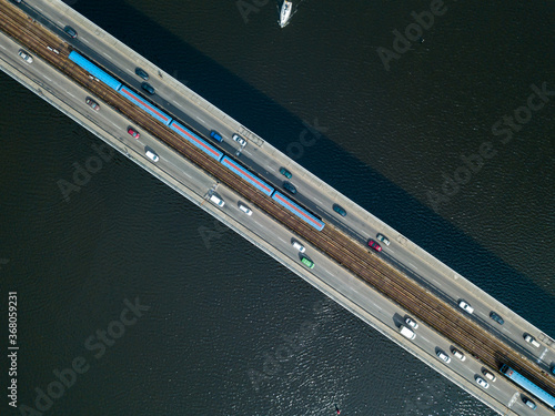 Aerial drone top view. Kiev metro trains travel across the bridge over the Dnieper River. Clear sunny summer day.
