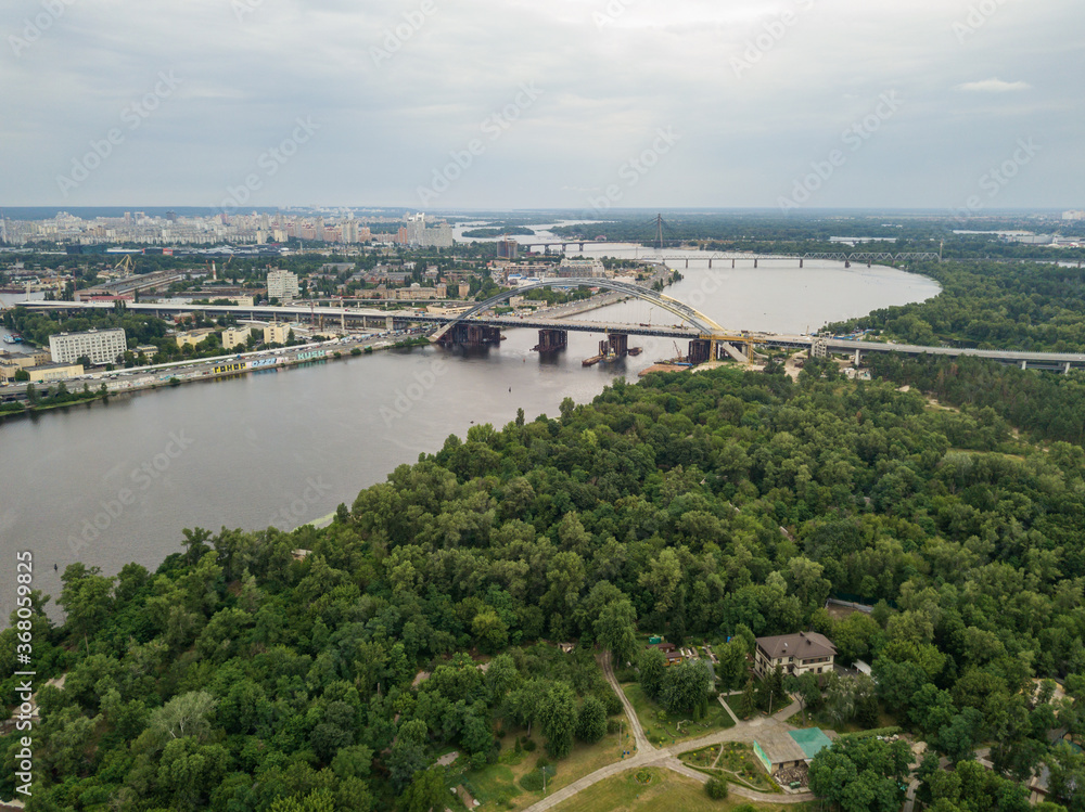 Construction of a bridge across the Dnieper river in Kiev. Aerial drone view.