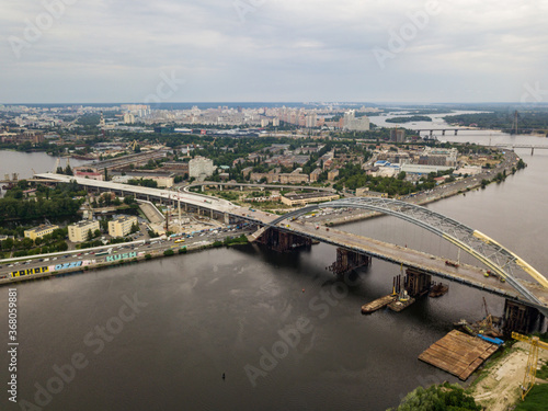 Construction of a bridge across the Dnieper river in Kiev. Aerial drone view.