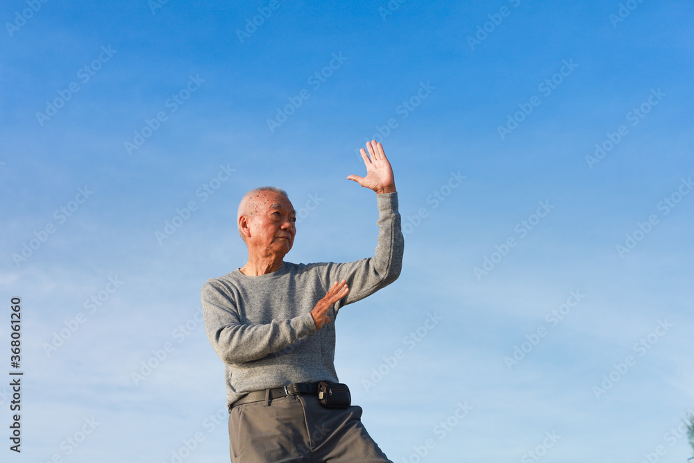 Asian Senior old man practice Taichi Chinese Kungfu on the beach Asian Senior old man practice Taichi Chinese Kungfu on the beach