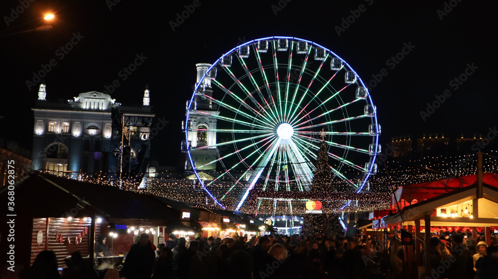 lluminated Ferris Wheel on Kontraktova Square in Kiev in the evening.