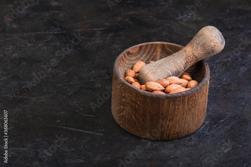 Wallpaper Mural Almonds on a mortar with a pestle on a dark background