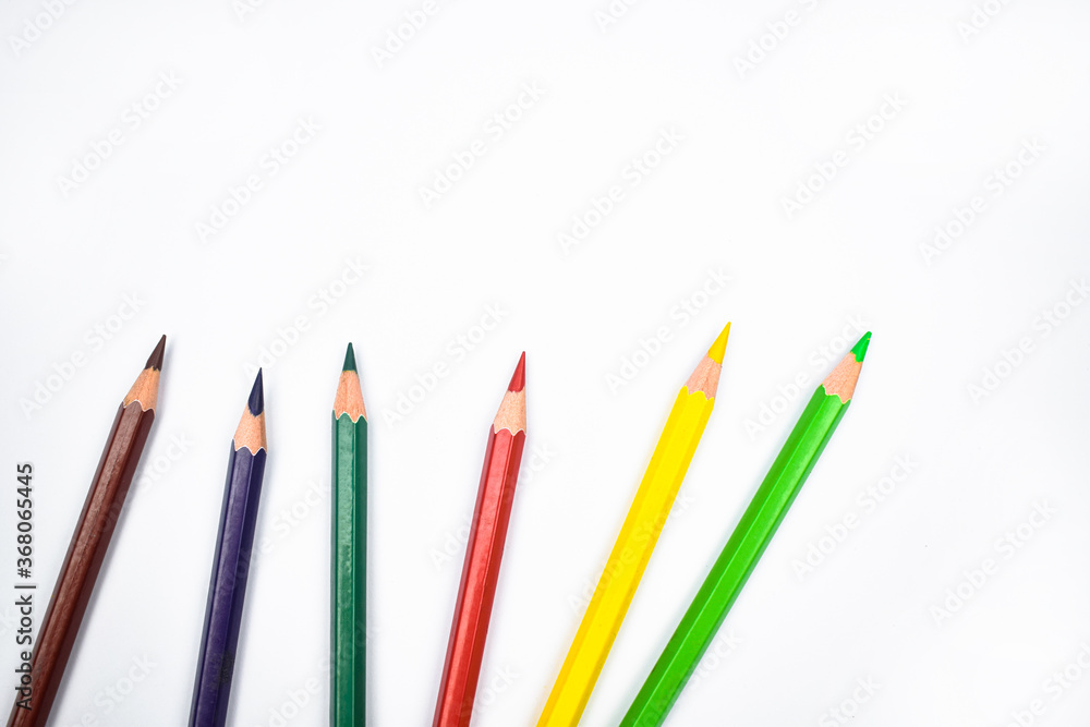 Seven different colored wood pencil crayons placed on a white background Seven different colored wood pencil crayons placed on a white background