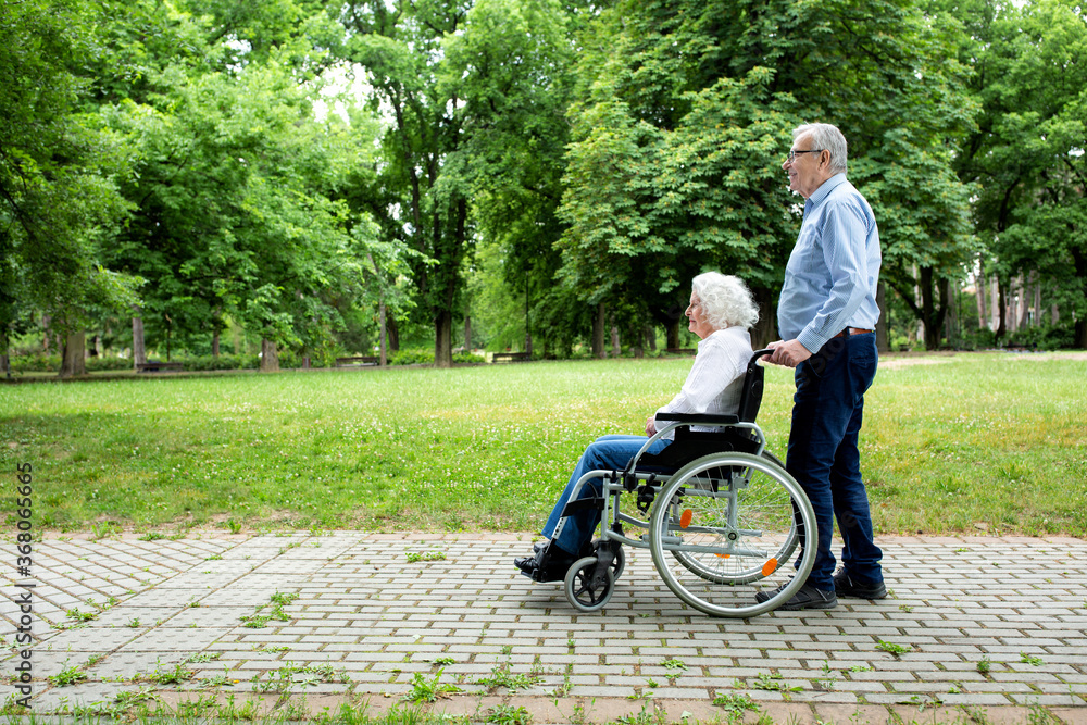 Senior couple rolling and strolling in the park