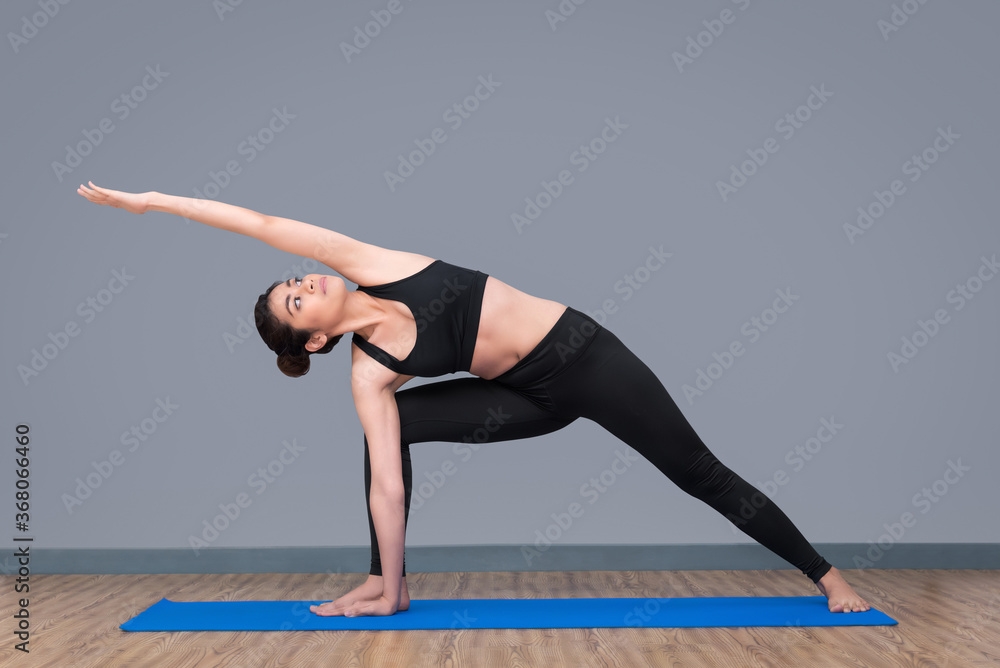 Asian woman practicing yoga pose at yoga healthy sport gym, yoga and meditation have good benefits for health