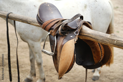 Photo of old leather saddle with stirrups