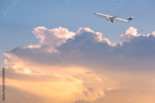 Commercial airplane flying over sunrise sky and clouds. Elegant Design with copy space for travel concept.