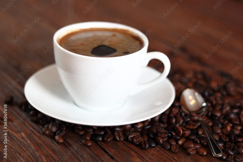 Cup of Coffee and Coffee Beans on wooden plank table Cup of Coffee and Coffee Beans on wooden plank table