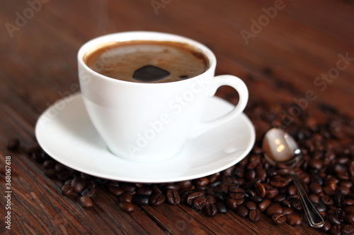 Cup of Coffee and Coffee Beans on wooden plank table