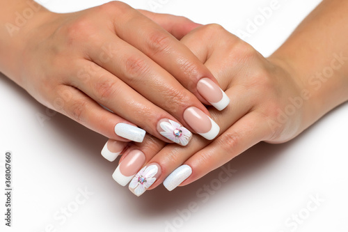 Wedding french white manicure with white painted flower on a white background close-up on long square nails. Gel design.