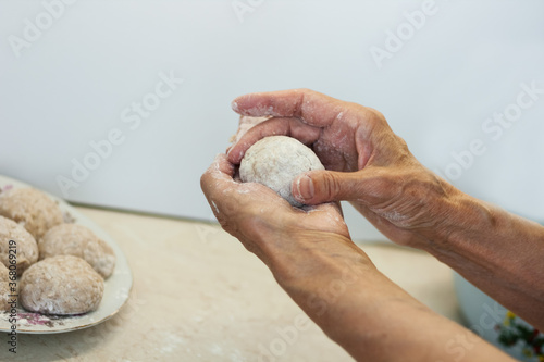 homemade meatballs - female hands make minced meatballs - traditional Italian cuisine.