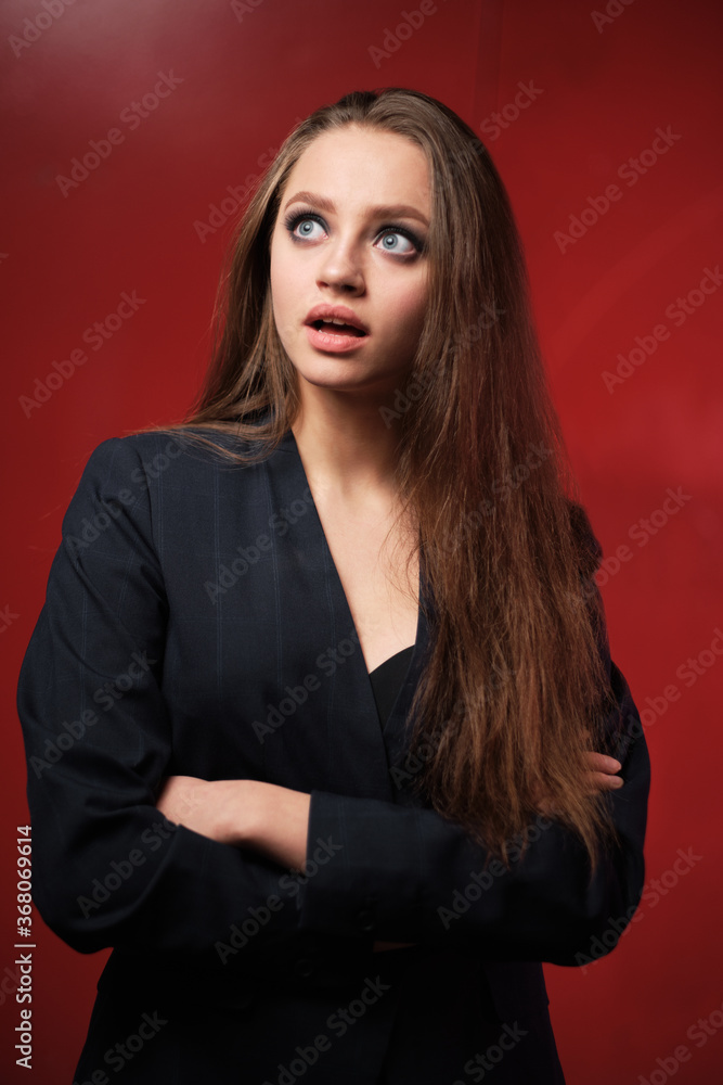 Portrait of a young beautiful girl 20-25 years old with different emotions in a jacket on a red background Portrait of a young beautiful girl 20-25 years old with different emotions in a jacket on a red background