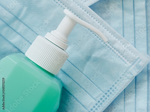 Closeup shot of a bottle of hand sanitizer and facemasks - pandemic covid 19 photo