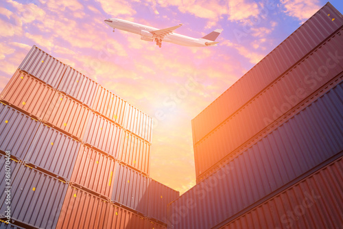 Cargo Flight flying over Colourful stack of cargo shipping containers in shipping yard.Photo concept for Global business containers shipping,Logistic,Import and Export industry.