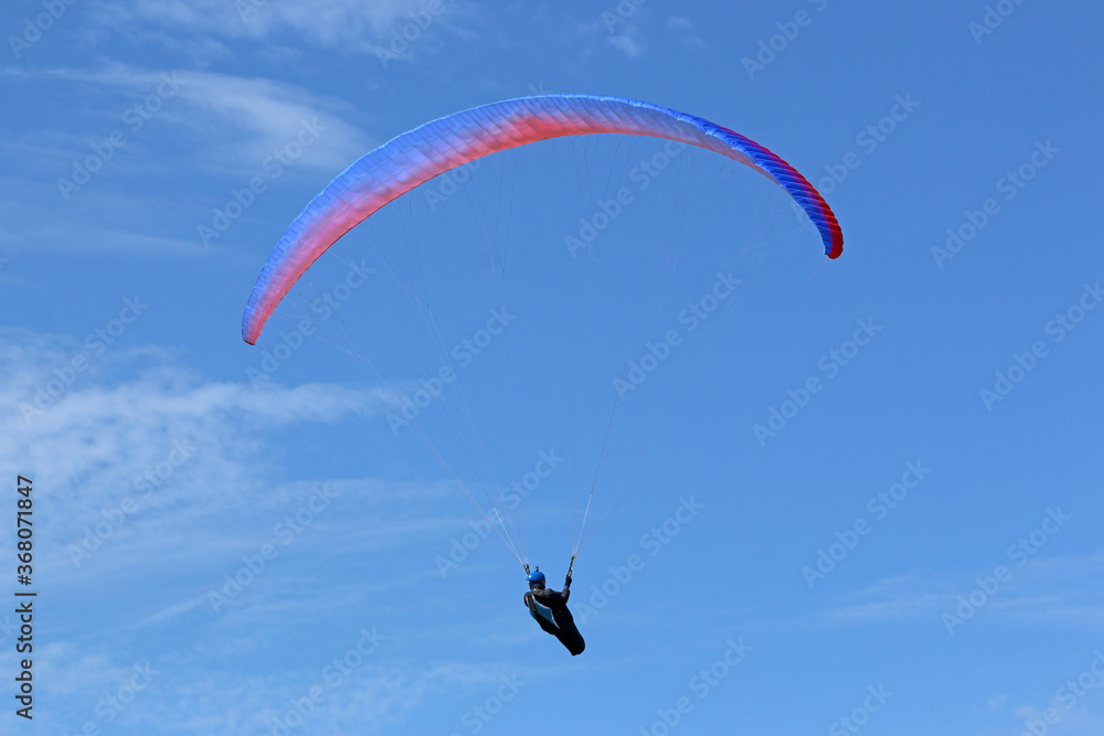 Paraglider flying wing in a blue sky Paraglider flying wing in a blue sky