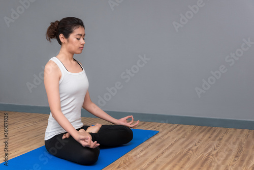 Canvas Print Asian woman keep calm and meditates while practicing yoga to at yoga sport gym