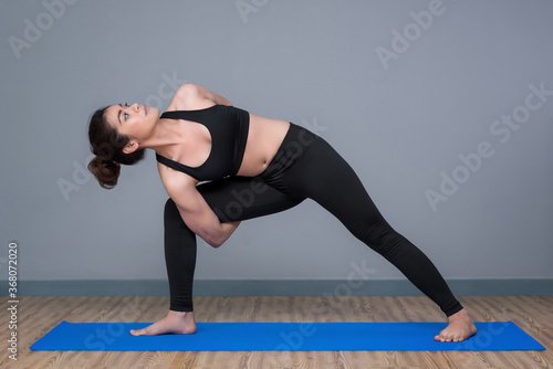 Asian woman practicing yoga pose at yoga healthy sport gym, yoga and meditation have good benefits for health.