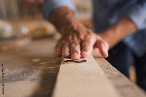 Close up of male hands using sandpaper