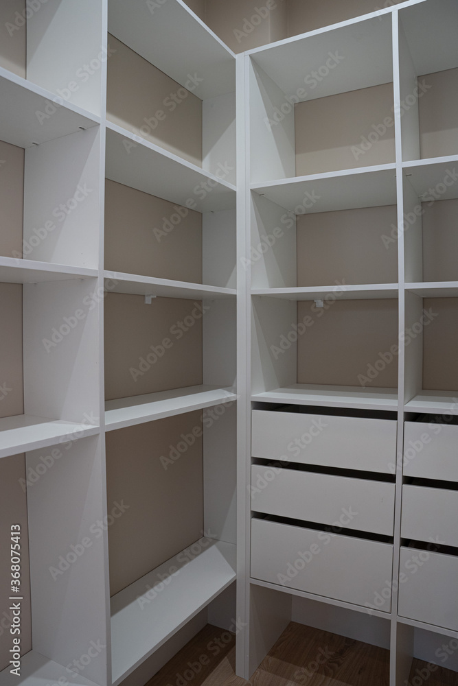 Fototapeta premium Light empty wardrobe, with white shelves
