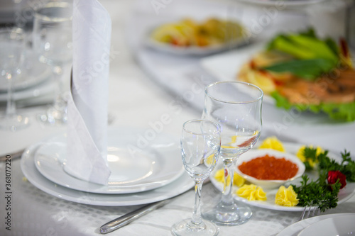 Banquet table with food and dining utensils.
