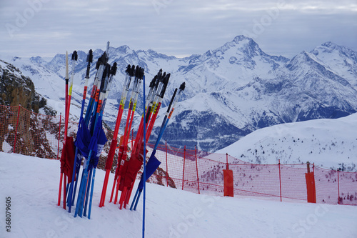 bunch of colorful ski poles or gates for slalom racing unused on the french ski slopes in the alps