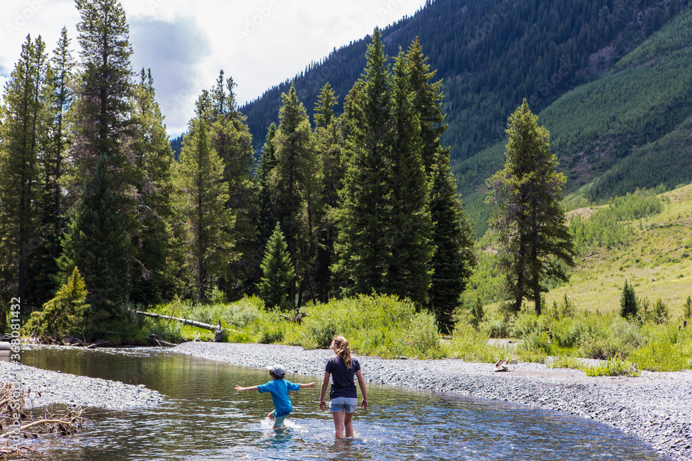 teenage girl and her younger brother hiking in mountain lake, Crested Butte, CO. teenage girl and her younger brother hiking in mountain lake, Crested Butte, CO.