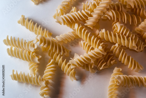 fusilli macaroni Italian dry raw pasta bronze drawn white background top view