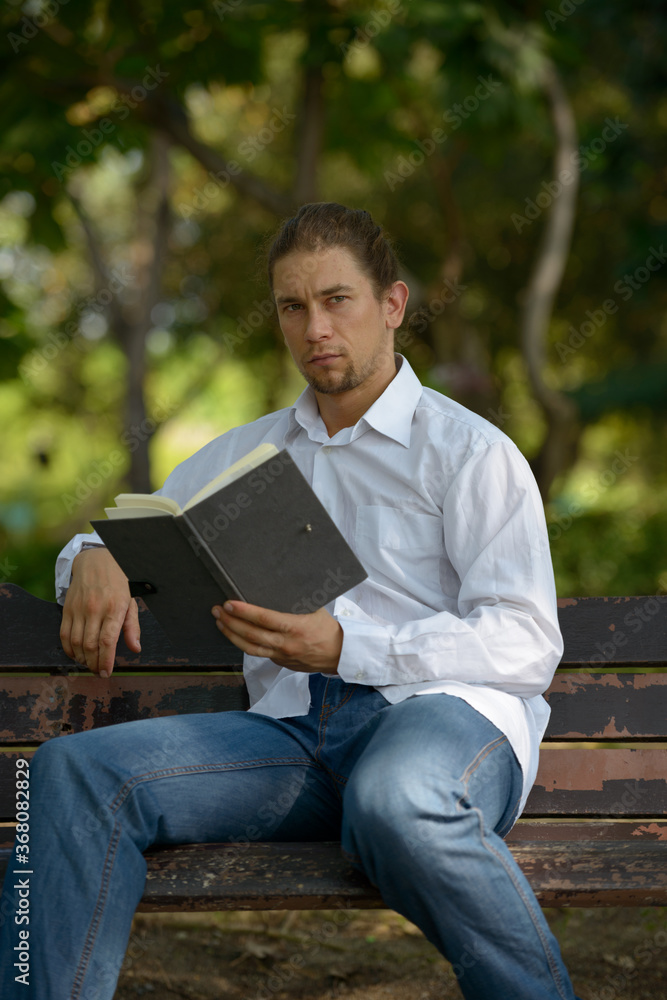 Handsome bearded businessman with long hair at the park Handsome bearded businessman with long hair at the park