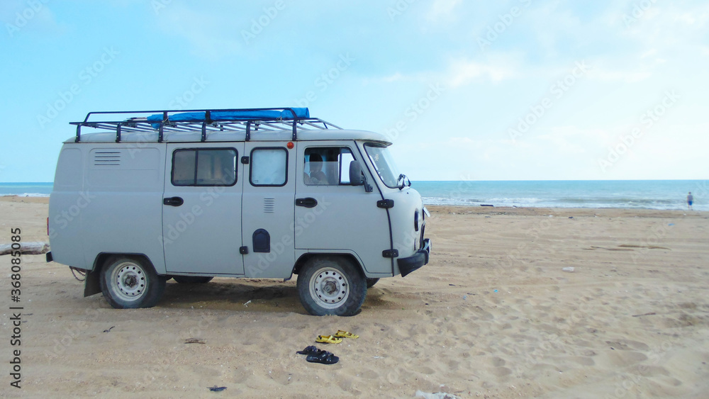 Gray truck against the background of the summer sea and blue sky.