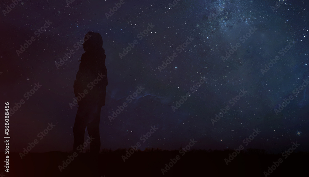 Silhouette of a woman in the night starry sky