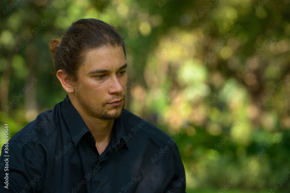 Handsome bearded businessman with long hair at the park Handsome bearded businessman with long hair at the park