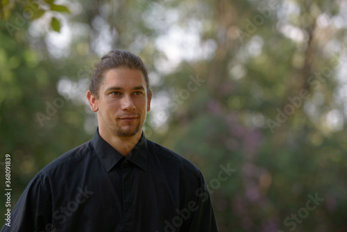 Handsome bearded businessman with long hair at the park © Ranta Images