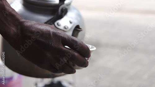 Traditional Tanzanian Street Black Coffee in Aluminium Teapot. Pouring Coffee in a small Pot in Dar Es Salaam. photo