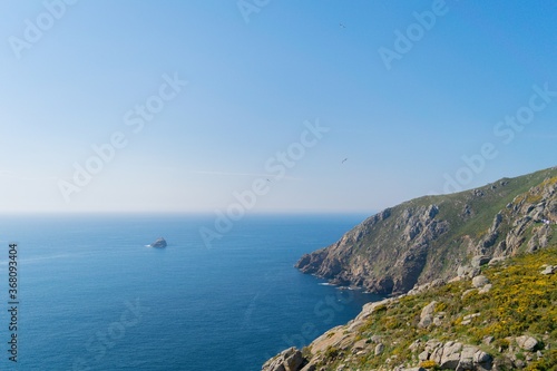 Beautiful view of Cape Finisterre in Fisterra, Spain with a blue sky background photo