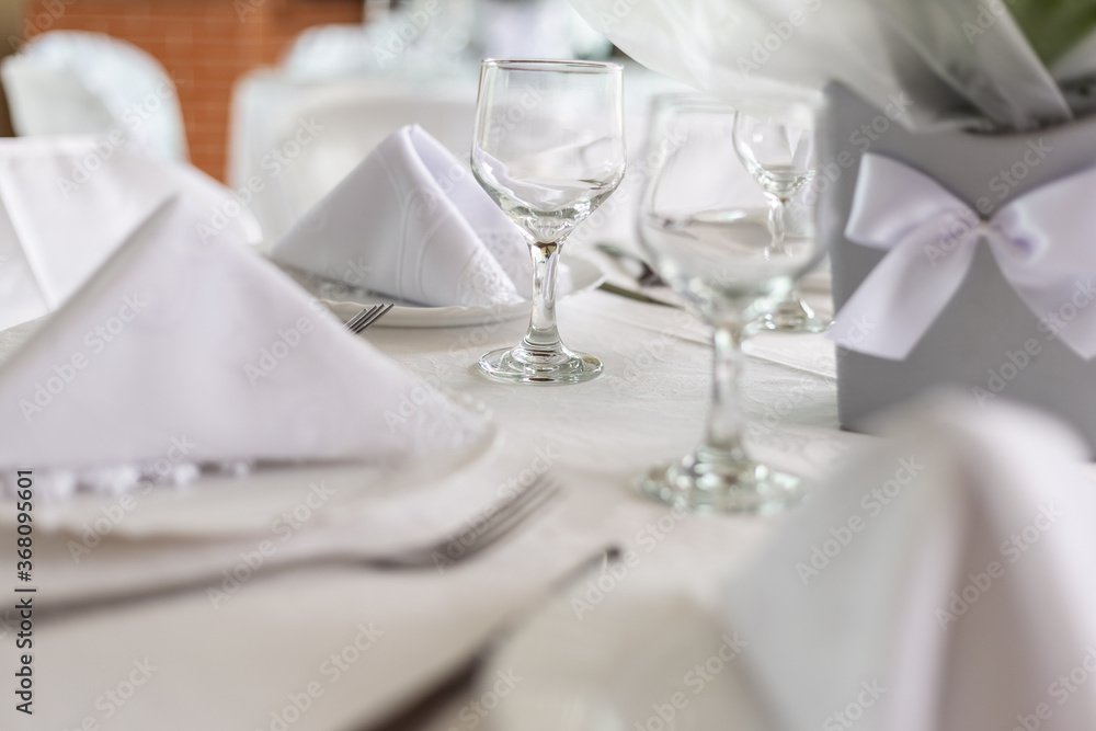 Mesa de convidados com forro branco, pratos, copos e guardanapos dentro dos pratos. Mesa de convidados com forro branco, pratos, copos e guardanapos dentro dos pratos.
